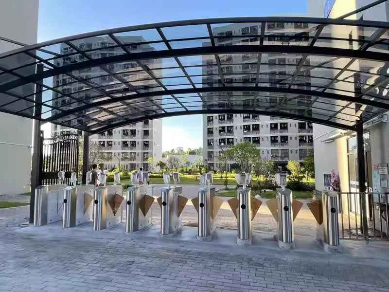 Modern glass awning sheltering security turnstiles at apartment entrance, Kings Awning style