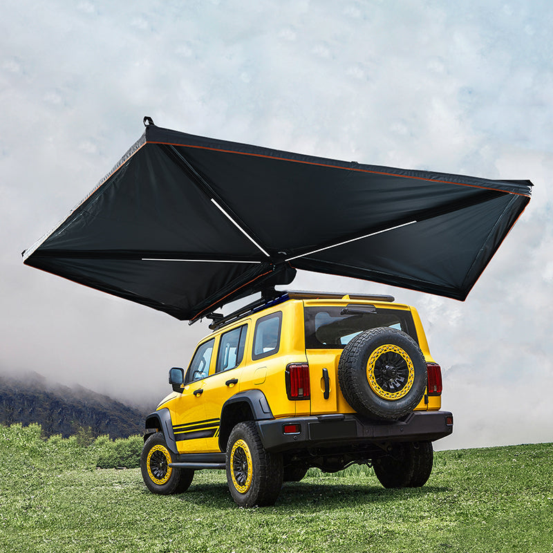 Yellow SUV with large rooftop awning on grassy field, Kings Awning outdoor shade solution