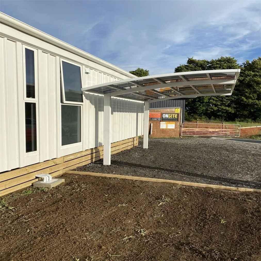 Modern white awning attached to house exterior, custom Kings Awning for outdoor space.